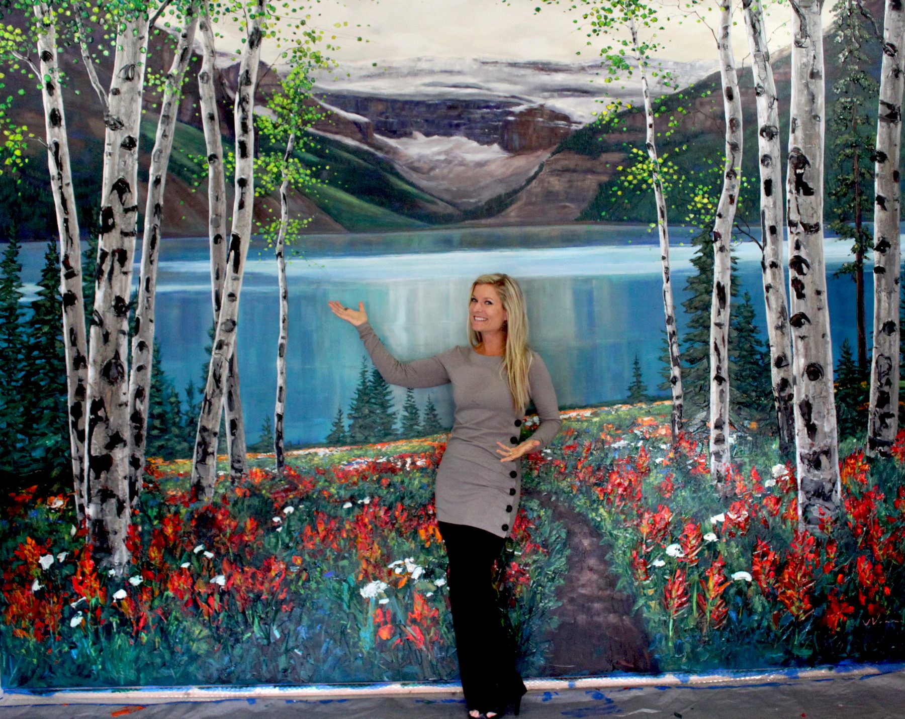 Jennifer Vranes with a large birch, lake and mountain mural